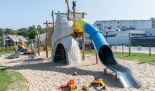 Blick vom Hof auf das Ferienhaus mit kleinem eigenen Spielplatz