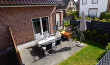 Terrasse mit Sonnenschirm und Möbel Bollerwagen Fahrräder