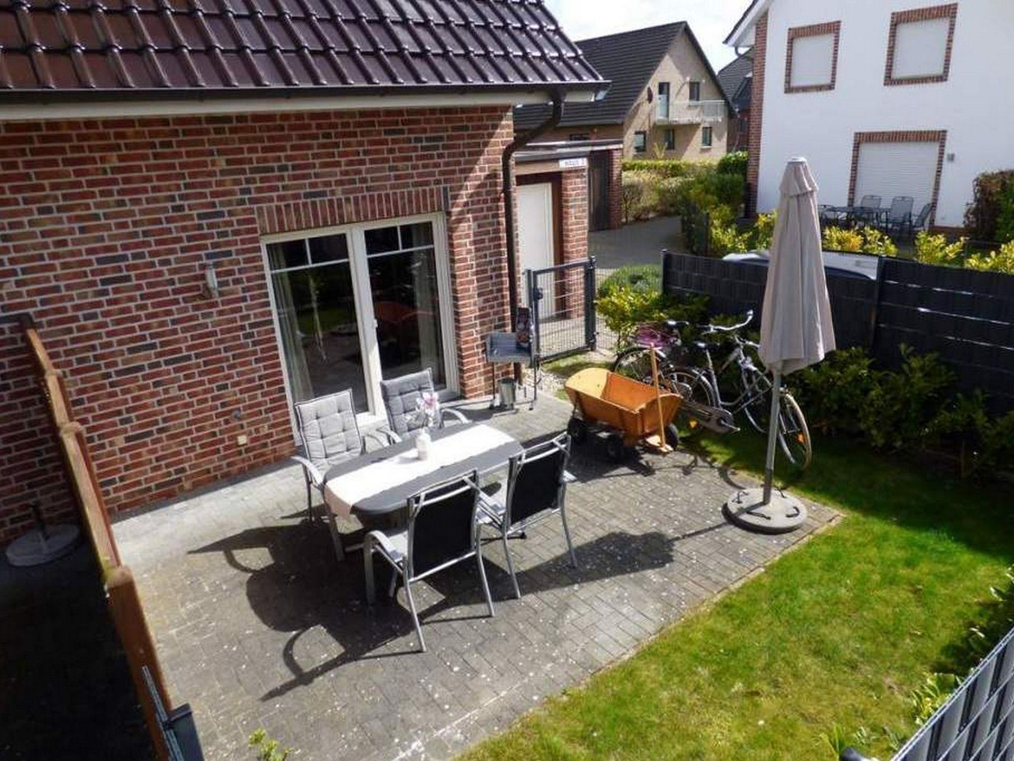 Terrasse mit Sonnenschirm und Möbel Bollerwagen Fahrräder