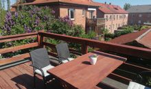 - große Dachterrasse mit Sitzmöbel, Sonnenschirm und Tisch