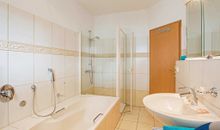 1. Badezimmer mit Badewanne, Dusche und WC
