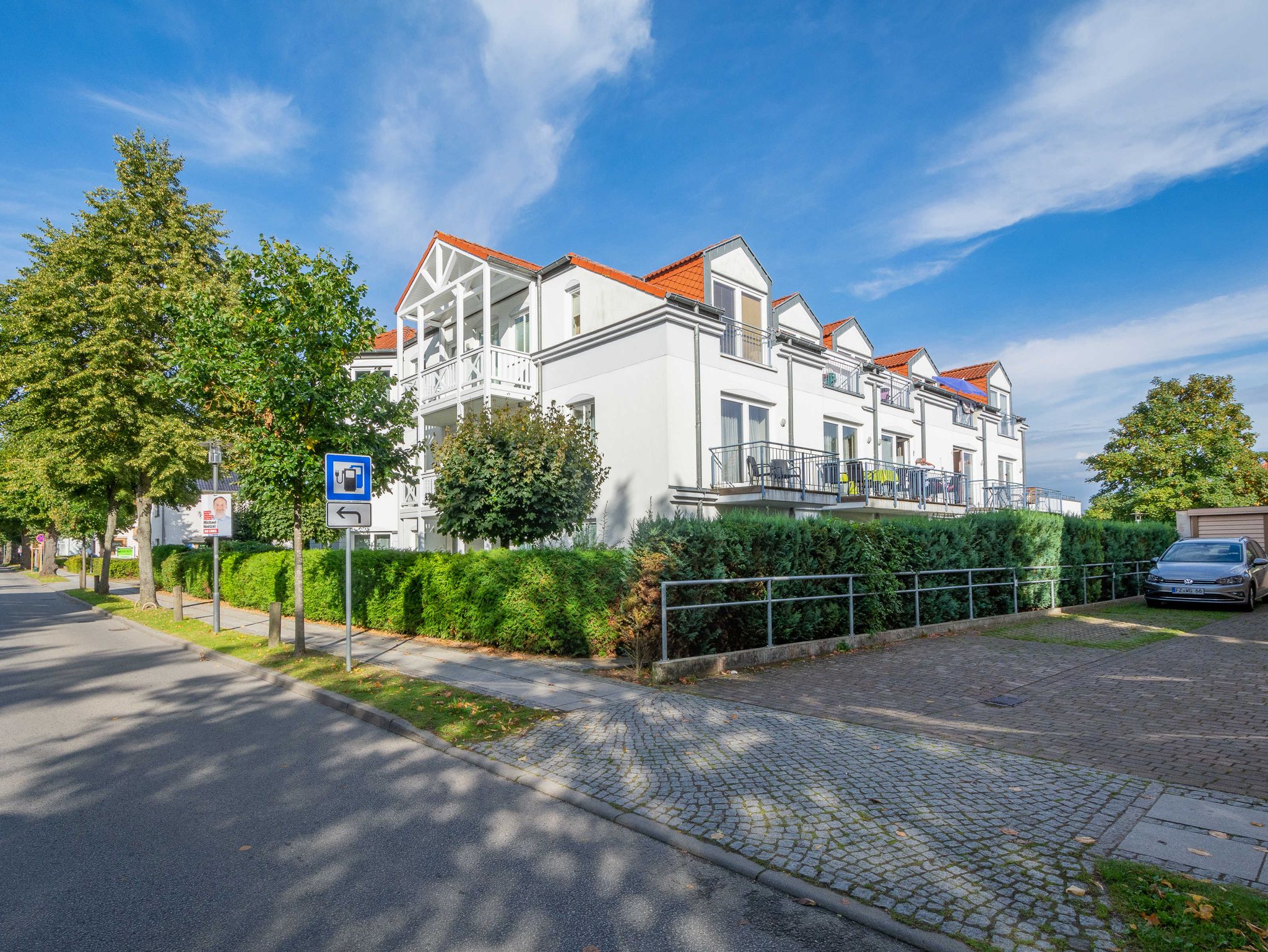 Straße vor dem Haus Baabe mit Parkplätzen sowie Sicht Richtung Supermarkt. Zu erreichen in ca. 80 m links. Links von dem Holzboot, der Minigolfplatz.