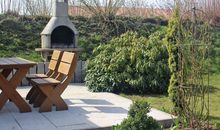 Sitzecke mit Steingrill im Garten